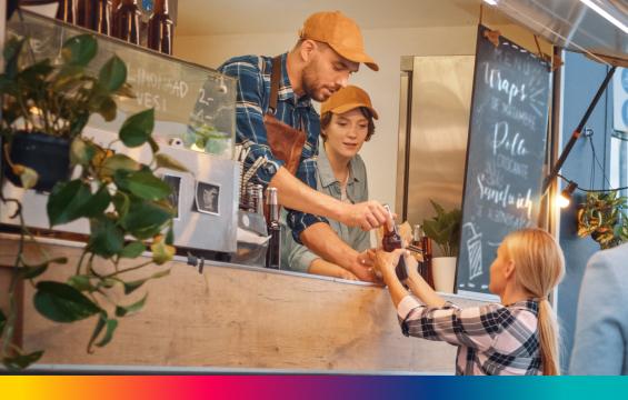 Vendedores en food truck cobrando una venta