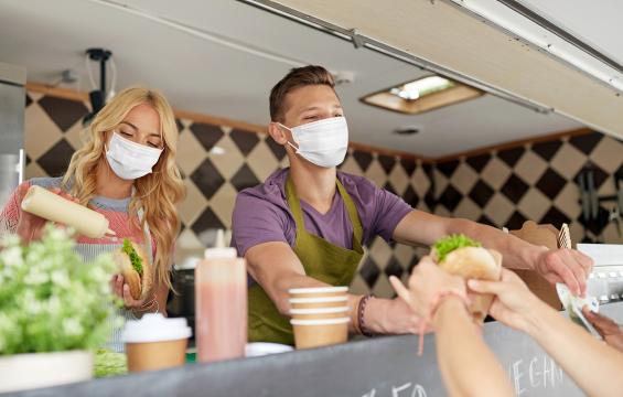 Vendedores en food truck cobrando una venta